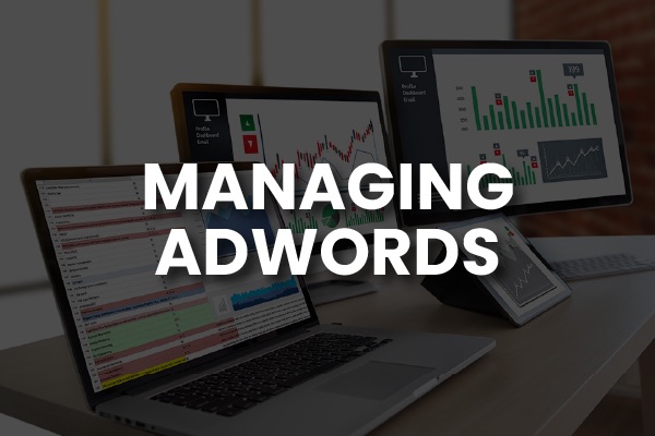 A computer set-up with the words, "managing Adwords."